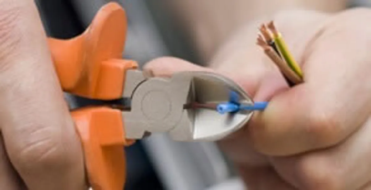 licensed electrician performing precise wire cutting and preparation during electrical service in Raleigh, NC